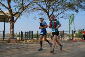 Runners on trail with elephant in background Thailand