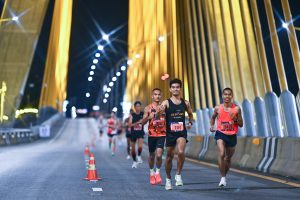Runners crossing bridge during Defence Run Bangkok night race