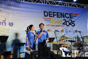 Event hosts speaking on stage at Defence Run Bangkok