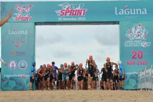 Triathletes running from the beach at the start of Laguna Phuket Triathlon