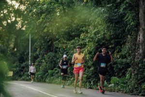 Runner celebrating with raised arms during Laguna Phuket Marathon 2025