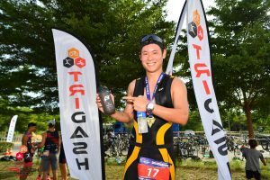 TriDash finisher holding medal Thailand
